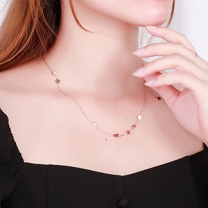 Close-up of rose gold star choker necklace worn by a model on the collarbone