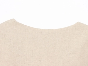 Gros plan du col en lin beige avec tissage texturé et finitions de couture propres