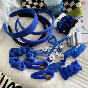 Flat lay of navy blue hair accessory set featuring scrunchies, headbands, and floral clips