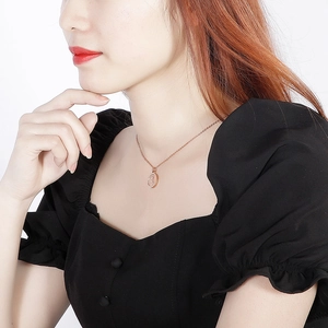 Detail of 18k rose gold plated portrait medallion necklace worn by a fashion model