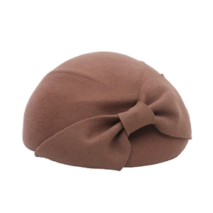 Close-up of elegant dark brown wool felt beret with a large decorative bow detail