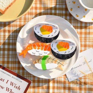 Detailed view of creative sushi-shaped hair claws made of acetate on a white plate