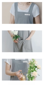 Detail view of washed cotton apron featuring widened shoulder straps and large pockets
