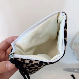 Macro detail of leopard print cotton pouch showing interior lining and zipper closure