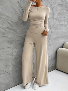 Macro detail of apricot knit long sleeve top and high-waist wide-leg trousers set for women