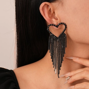 Gothic style black heart earrings with sparkling rhinestone tassels worn by a model