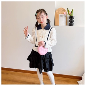 Girl wearing a white tweed jacket and pink heart-shaped quilted chain shoulder bag