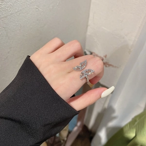 Detail of silver bow butterfly ring with sparkling zircon stones on a woman's finger