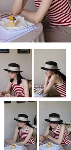 French vintage black straw boater hat with beige ribbon shown in a cafe setting