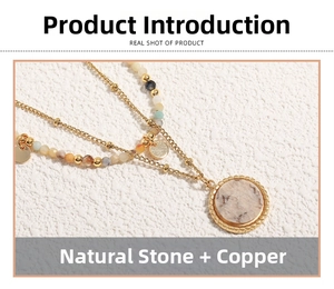 Detail of layered gold-plated brass necklace featuring natural stones and a round pendant