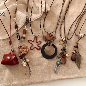 Vintage bohemian necklace set with feather stars and wooden beads on burlap