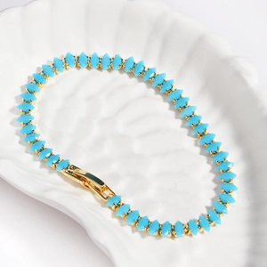 Detail of turquoise marquise-cut stones set in gold-plated tennis bracelet links