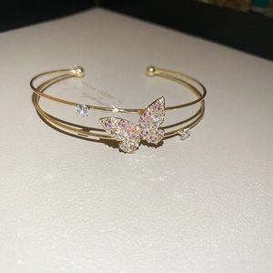 Detail of gold double-layer butterfly cuff with pink zircon pave setting and crystals
