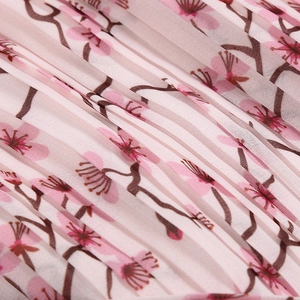 Gros plan sur tissu plissé à fleurs avec fleurs de prunier roses et texture mousseline