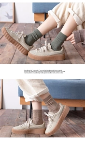 Close-up of olive green and brown ribbed cotton knee socks with platform suede sneakers