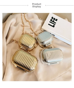 Close-up of metallic mini suitcase bags with vertical stripes and sphere locks