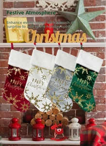 Détail de chaussettes de Noël en velours avec flocons dorés et texte Merry Christmas