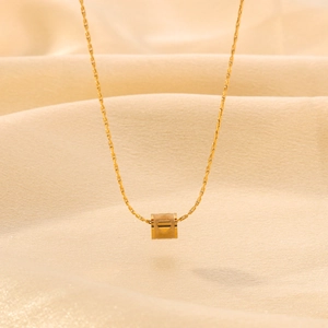 Minimalist 18k gold plated round pendant necklace on a beige silk background
