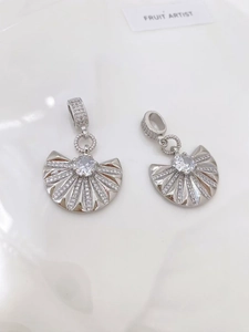 Macro view of crystal-encrusted fan-shaped pendants in silver-tone polished finish