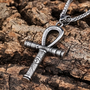 Vintage stainless steel Ankh cross necklace with Eye of Horus on natural wood backdrop