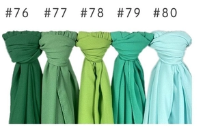 Vertical display of solid pearl chiffon hijabs in five different shades of green fabric