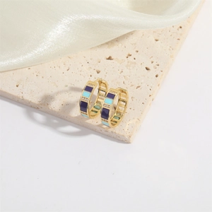 Detail of gold hoop earrings with purple and blue enamel and tiny zircon stones