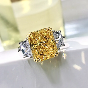 Macro shot of rectangular yellow high carbon diamond ring with shield-cut side stones