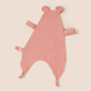Close-up of pink muslin cotton baby comforter with bear ears and soft wrinkled texture