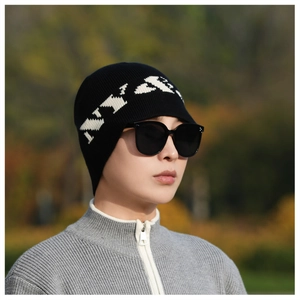Close-up of black ribbed knit beanie featuring white jacquard lettering for winter
