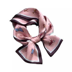 Elegant pink silk scarf with horse print tied in a bow on a clean white background