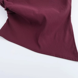 Macro shot of dark wine red sleeveless top showing hemline stitching and fabric texture