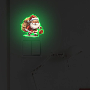 Luminous Santa Claus wall sticker glowing green in the dark above a light switch