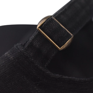 Macro view of black cotton baseball cap with adjustable brass metal buckle detail