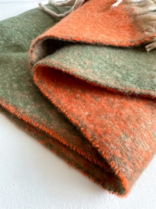 Detailed texture of thick gradient orange and green cashmere-feel scarf with tassels