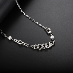 Close-up of silver Cuban link chain with embedded crystals and white pearls detail