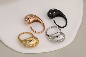 Detailed view of teardrop rings in gold, rose gold, silver, and black with rhinestones