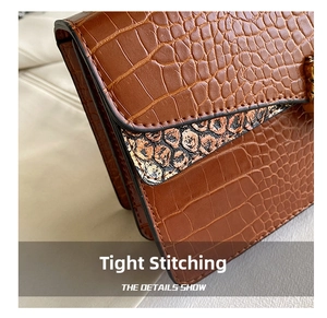 Detailed macro view of brown crocodile texture leather and precise stitching on flap bag