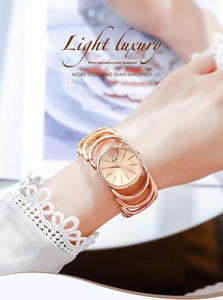 Detail of rose gold bracelet watch with minimalist dial and hollow metal strap