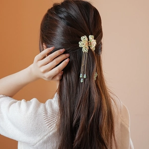 Elegant flower hair claw with long pearl tassels on wavy hair for a graceful style