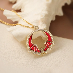 Vintage gold necklace with red enamel bat pendant and clear crystals on coral stones