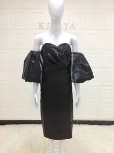 Detail of black off-shoulder party dress with puffy lantern sleeves and satin texture