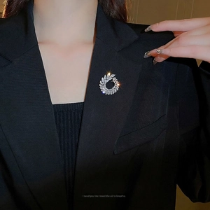 Elegant zircon leaf wreath brooch in a circular design pinned on a black business blazer