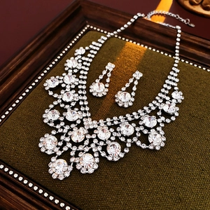 Close-up of elegant silver tiered necklace and drop earrings with sparkling rhinestones
