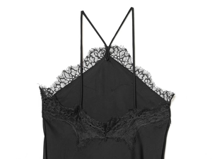 Detail of black silk-satin halter dress featuring intricate lace trimming and refined texture