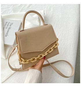 Chic beige crossbody bag with top handle and decorative acrylic chain detail