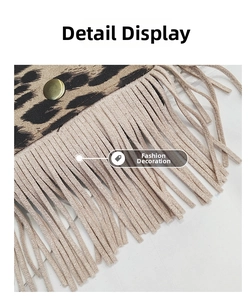 Close-up of leopard print fabric with long beige tassels and brass metal buckle detail