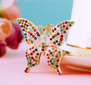 Macro shot of colorful rhinestones on a gold-plated metal butterfly keychain pendant