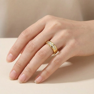 Detail of a wide gold titanium steel ring with micro-pave zircons worn on a model hand
