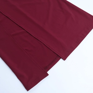 Details eines weinroten Strickkleids mit hohem Beinschlitz und präziser Verarbeitung