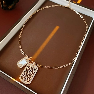 Makroaufnahme einer roségoldenen Kette mit Muschelanhänger in einer braunen Box